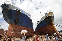 Typhoon Haiyan survivors on Sunday pass by two vessels that were washed ashore during the storm in Tacloban, a city in Leyte, a province in the central Philippines.